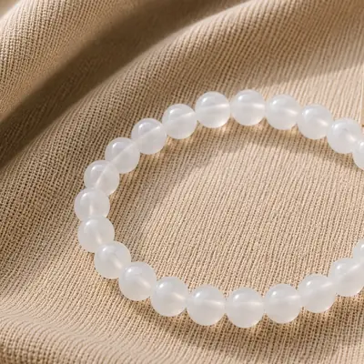 SNOW — Milchquarz-Perlenarmband auf Leinen